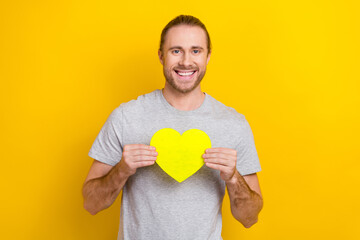 Sticker - Portrait of cheerful friendly guy long tail hair dressed light t-shirt hands hold yellow like icon isolated on yellow color background