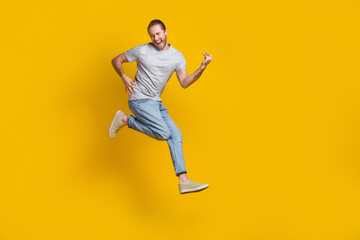 Sticker - Full length photo of cook cheerful man wear grey t-shirt jumping high playing guitar empty space isolated yellow color background