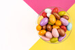 Almond candies, top view image of colorful almond candies. Stylish glass bowl. White copy space. Pink and yellow background. The sugar feast concept in Turkish called Ramadan, Ramazan, Şeker Bayramı.