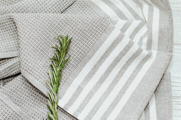 Wall Mural - Fresh green sprig of rosemary seasoning on table with kitchen towel.