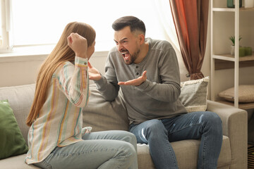 Wall Mural - Angry young couple quarreling at home. Domestic violence concept