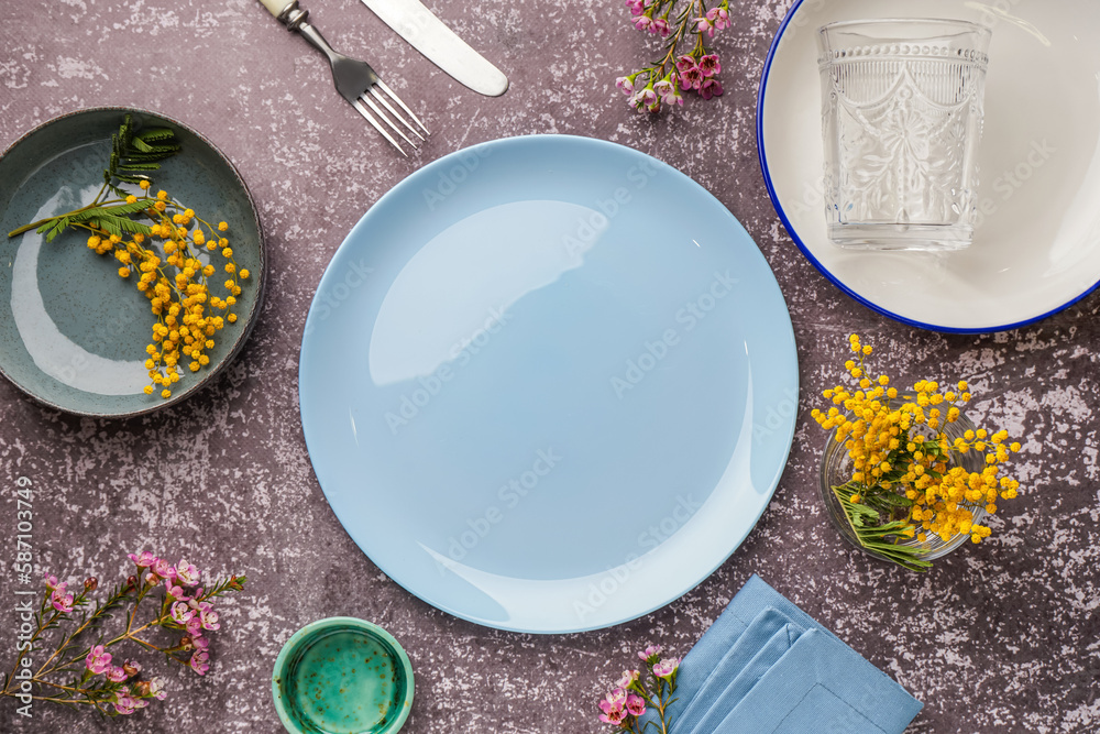 Composition with clean dishes and flowers on grey grunge table
