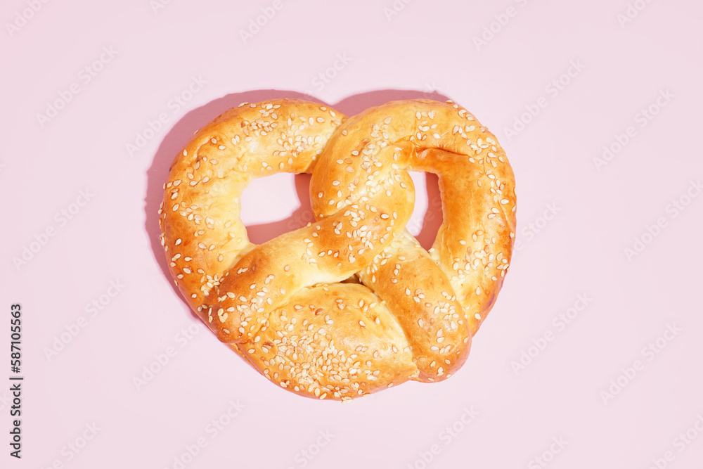 Tasty pretzel on pink background