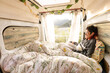 © VICTOR - woman reading in the camper van, caravan, at sunset, book, woman smiling in nature