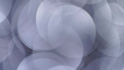 Wall Mural - Large Silver Bokeh Background. Smooth motion of lights on large defocused circles. Abstract moving background of glow silver bokeh circles lights. Can be used as background, overlay or transition. 