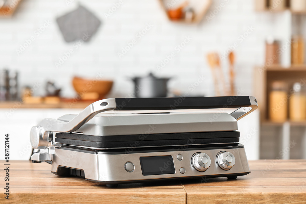 Modern electric grill on table in kitchen