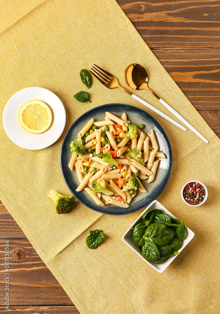 Plate with tasty pasta salad on wooden background