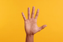 Man Giving High Five On Yellow Background, Closeup Of Hand