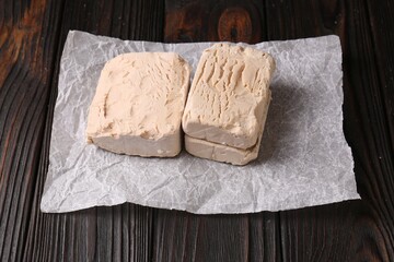 Pieces of fresh compressed yeast on wooden table