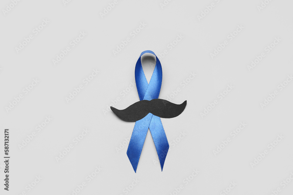 Blue awareness ribbon with paper mustache on grey background