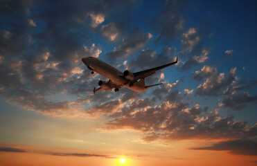 Wall Mural - Plane in sky during sunset, low angle view