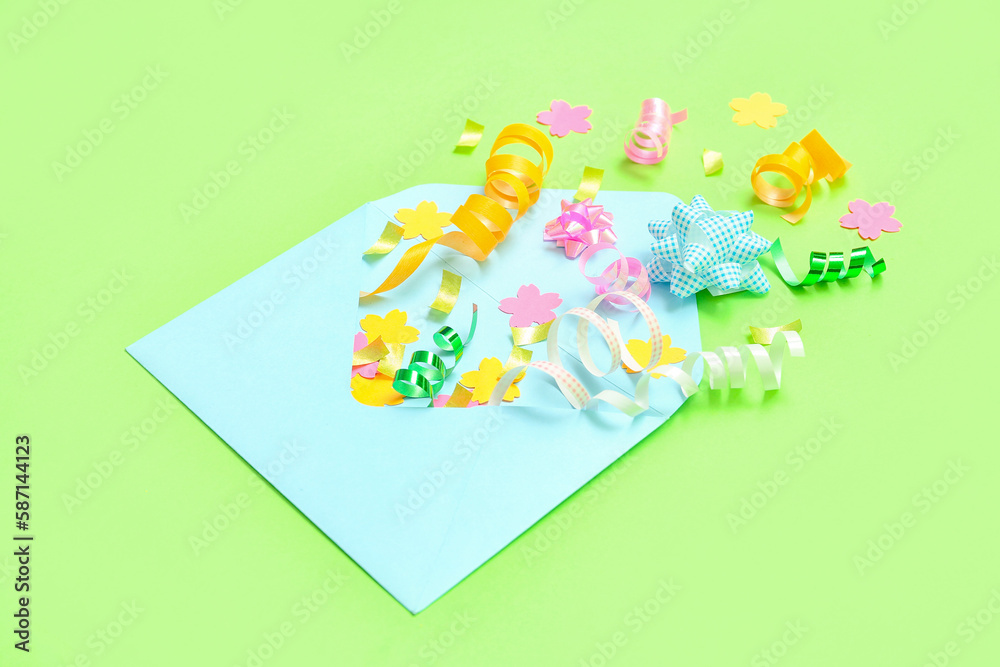 Composition with envelope and confetti on green background