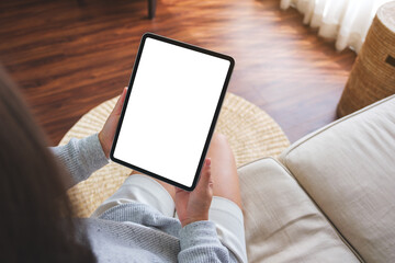 Top view mockup image of a woman holding digital tablet with blank desktop screen on sofa at home