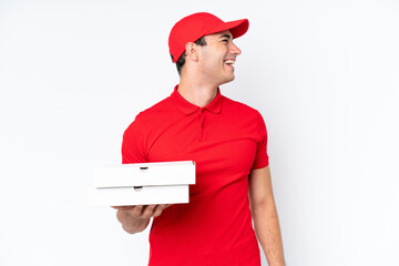 Wall Mural - Pizza delivery caucasian man with work uniform picking up pizza boxes isolated on white background laughing in lateral position