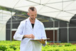 © Prathankarnpap - Portrait of handsome agricultural researcher recording data from during examining plants in industrial greenhouse