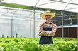 © Prathankarnpap - Successful farmer in apron standing with arms crossed in hydroponic greenhouse. Agriculture business concept