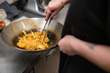 Wall Mural - woman chef hand cooking Noodle with chicken on restaurant kitchen