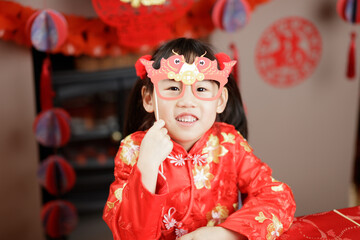 young girl with traditional dressing up celebrating Chinese new year against all kind of 