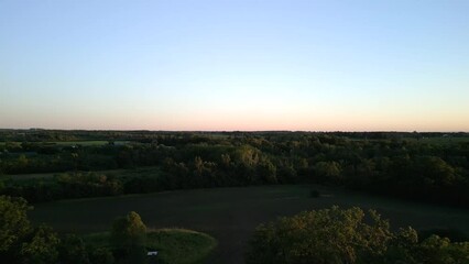 Sticker - Drone view of a countryside with green forests and fields under blue sky at sunset