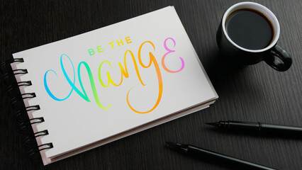 Wall Mural - BE THE CHANGE colorful hand lettering in notebook with cup of espresso and pens on black wooden desk