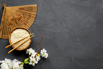 Wall Mural - Asian table setting - rice bowl with cherry branch and fan. Top view