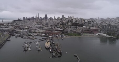 Wall Mural - San Francisco Cityscape and Fisherman's Wharf in Background. Cloudy Day. Aquatic Park Pier, Cove and Municipal Pier in San Francisco. Maritime National Historic Park in Background. California