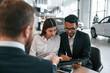 © standret - Family is buying new automobile. Three people are working together in the car showroom