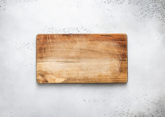 Wall Mural - Empty scratched wooden cutting chopping kitchen board on light background.Top view.