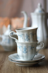 Vintage white tea set with pale blue flowers. Selective focus.