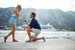 © luckybusiness - A young guy is proposing his girlfriend while they spending a holiday on the seaside. Love, relationship, holiday, sea