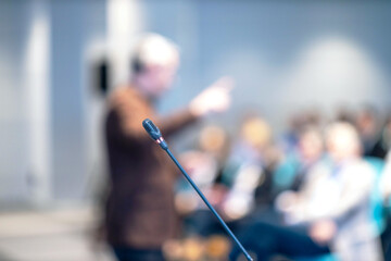 Blurred public speaker gesturing and using nonverbal communication during presentation, conference, training or workshop. Body language concept.
