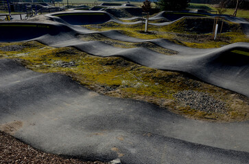 Sticker - bike path in the car park Pumping (moving up and down) is used instead of pedaling and bouncing to move bicycles, scooters, skateboards and inline skates along large yellow pumptrack track