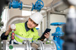 © เลิศลักษณ์ ทิพชัย - 1 male industrial engineer controls the water system in the industrial plant and inspects the water storage tank system in the factory.