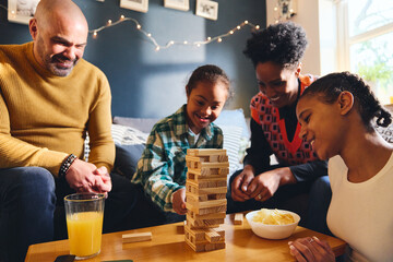 Wall Mural - Boy with Down syndrome playing board game with family at home