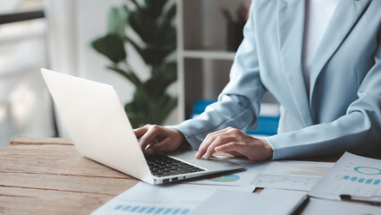 A business man is checking company financial documents and using a laptop to talk to the chief financial officer through a messaging program. Concept of company financial management.