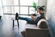 © BullRun - Happy man using smartphone in living room at home
