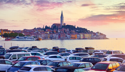 Wall Mural - Rovinj Croatia. Sunrise sky above vintage town at Istria peninsula in Adriatic Sea. View from cars parking. Old Mediterranean architecture and buildings. Coastline tower of Church Saint Euphemia