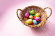 Schokoladen Oster Eier in Korb auf pinkem Hintergrund
