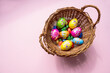 Schokoladen Oster Eier in Korb auf pinkem Hintergrund
