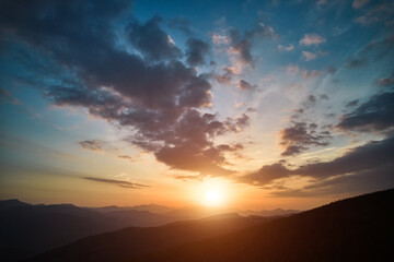 panoramic view of bright evening sun and dramatic cloudy sky over mountains. magnificent scenery of 