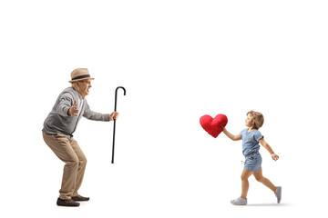 Wall Mural - Little girl running to hug her grandfather and carrying a red heart