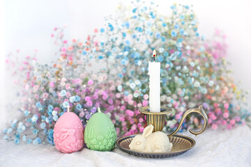 Canvas Print - decorative Easter bunny, eggs and candlestick, gentle colorful flowers close up on blurred light background. Easter holiday, Ostara concept. festive composition for spring season. greeting card design