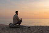 Fototapeta Paryż - young man with shirt, watching the sunset on a beach