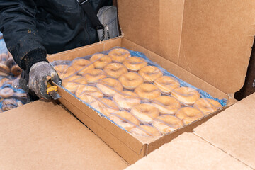 Many sweet and tasty round doughnuts, ring donuts covered with sugar. Chocolate-frosted doughnut. Symbol of sweeties, fried dough. A lot of sweet unhealthy food. Food waste, food production.