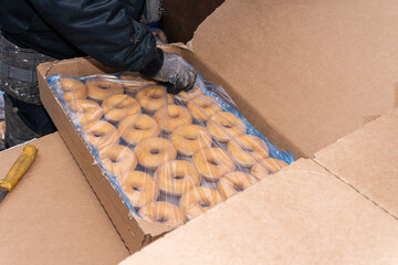 Many sweet and tasty round doughnuts, ring donuts covered with sugar. Chocolate-frosted doughnut. Symbol of sweeties, fried dough. A lot of sweet unhealthy food. Food waste, food production.