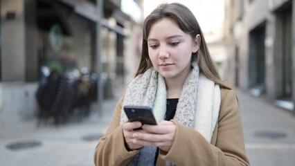 Sticker - Young blonde woman using smartphone with relaxed expression at street