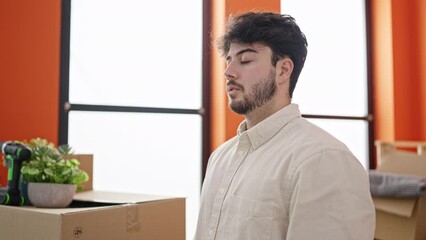 Wall Mural - Young hispanic man breathing with closed eyes at new home