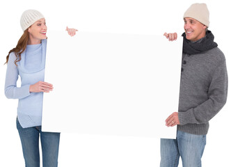 Wall Mural - Casual couple in warm clothing holding poster