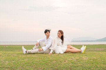 Happy young Asian couple in bride and groom clothing