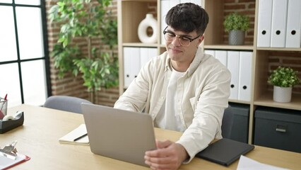 Sticker - Young hispanic man business worker opening laptop working at office